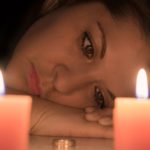 Woman sad looking at two candles. Wrongful Death