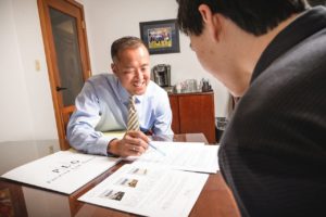 El abogado experimentado de Seattle, Patrick Kang, ayudando a un cliente