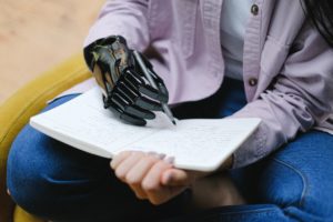 Víctima de mano amputada usando una prótesis para escribir