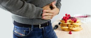 Man clenching his stomach from a foodborne illness