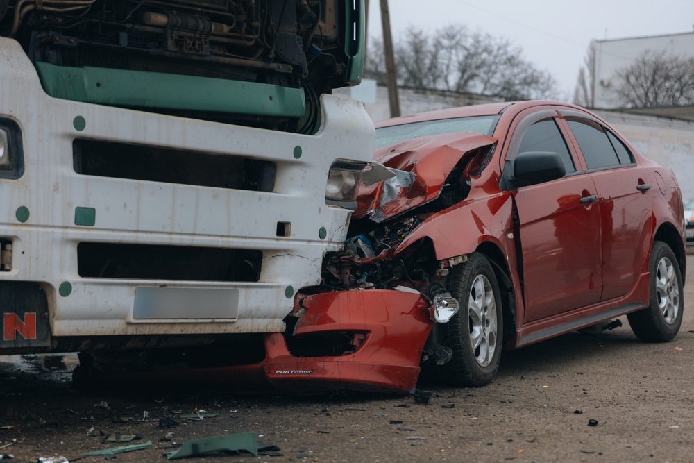 Las secuelas de una colisión entre un camión y un automóvil, en algún lugar el conductor del automóvil se pregunta qué hacer después de un accidente de camión.
