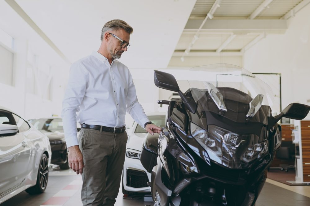 An insurance agent looks over a motorcycle for property damage to determine whether his health insurance company will cover the rider’s motorcycle accident injuries.