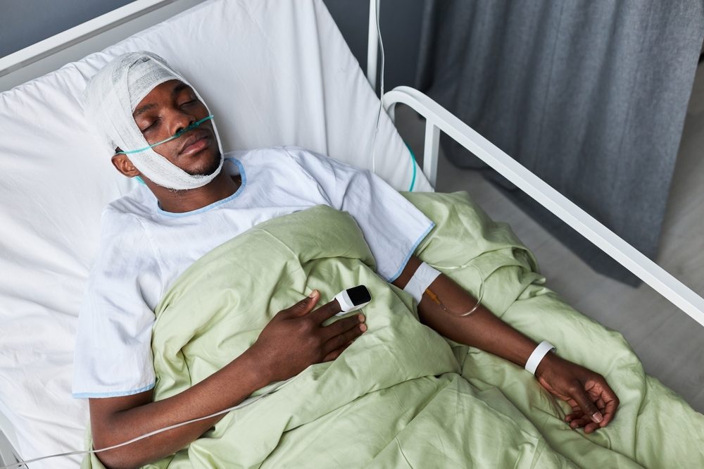 Un paciente con la cabeza vendada descansa en una cama de hospital tras sufrir un traumatismo craneoencefálico. La gravedad de la lesión y su impacto en la vida diaria pueden influir en el acuerdo.