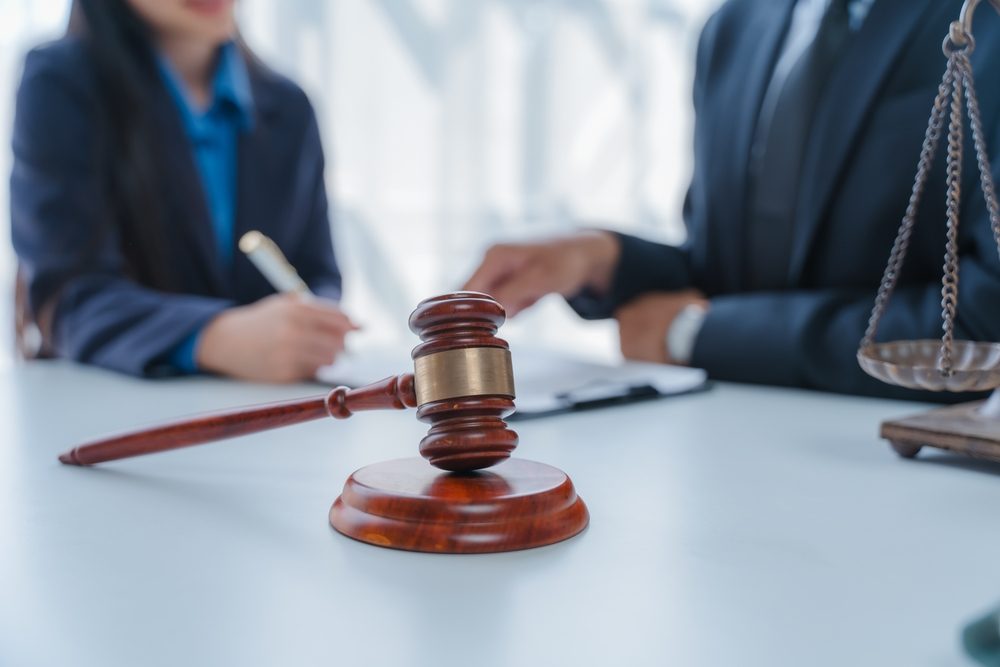A gavel in front of two lawyers in mediation. Is mediation legally binding in personal injury cases?
