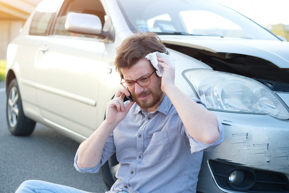 A man tending to his injured head after a car accident. What to do if you’re injured in a car accident in Bellevue.